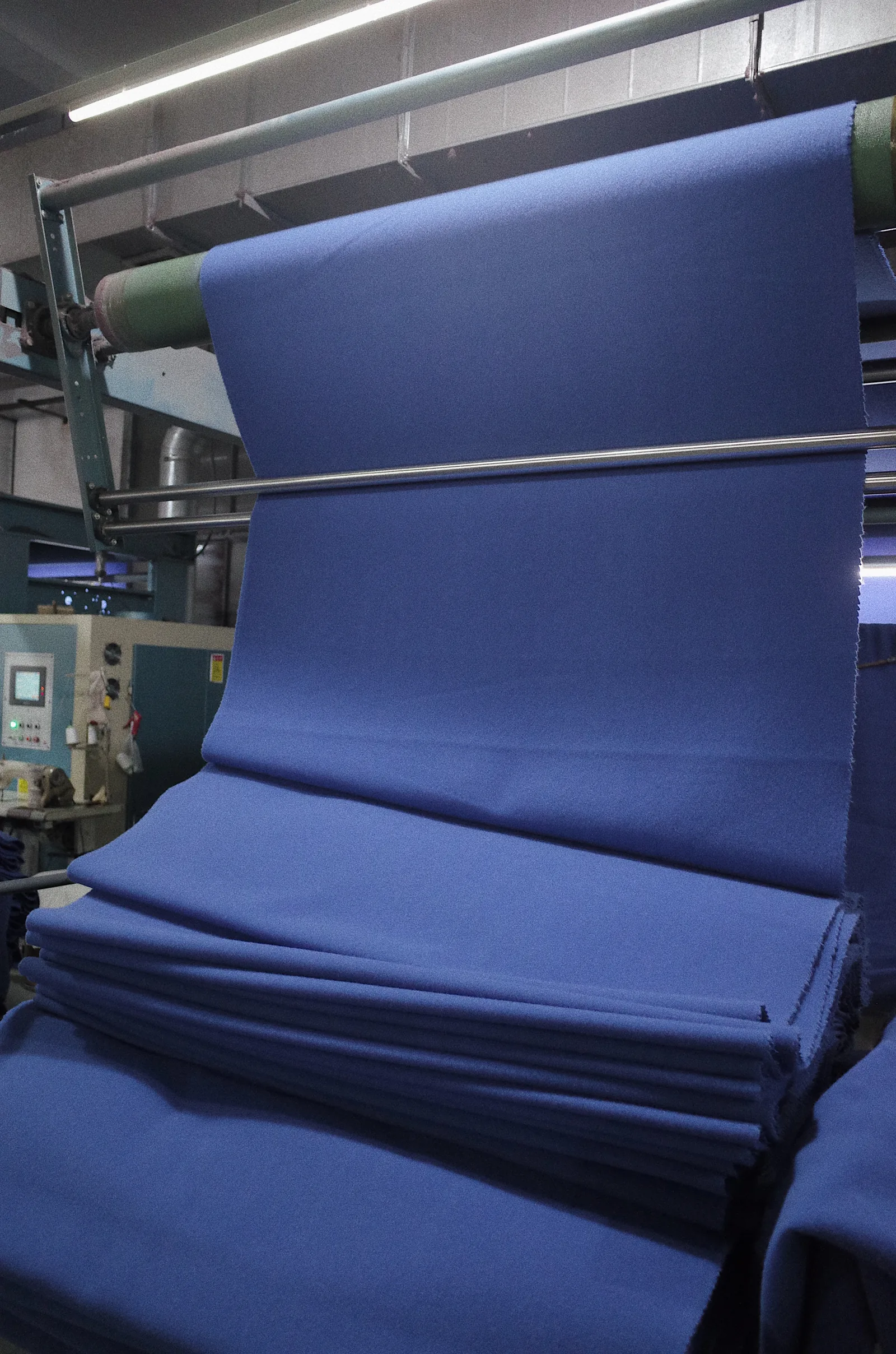 Blue woolen fabric leaving a finishing line in folded layers