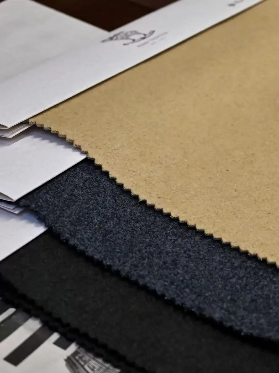 Camel charcoal and black woolen fabric swatches on development cards